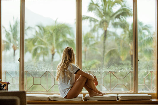 Woman sitting by the window looking outside